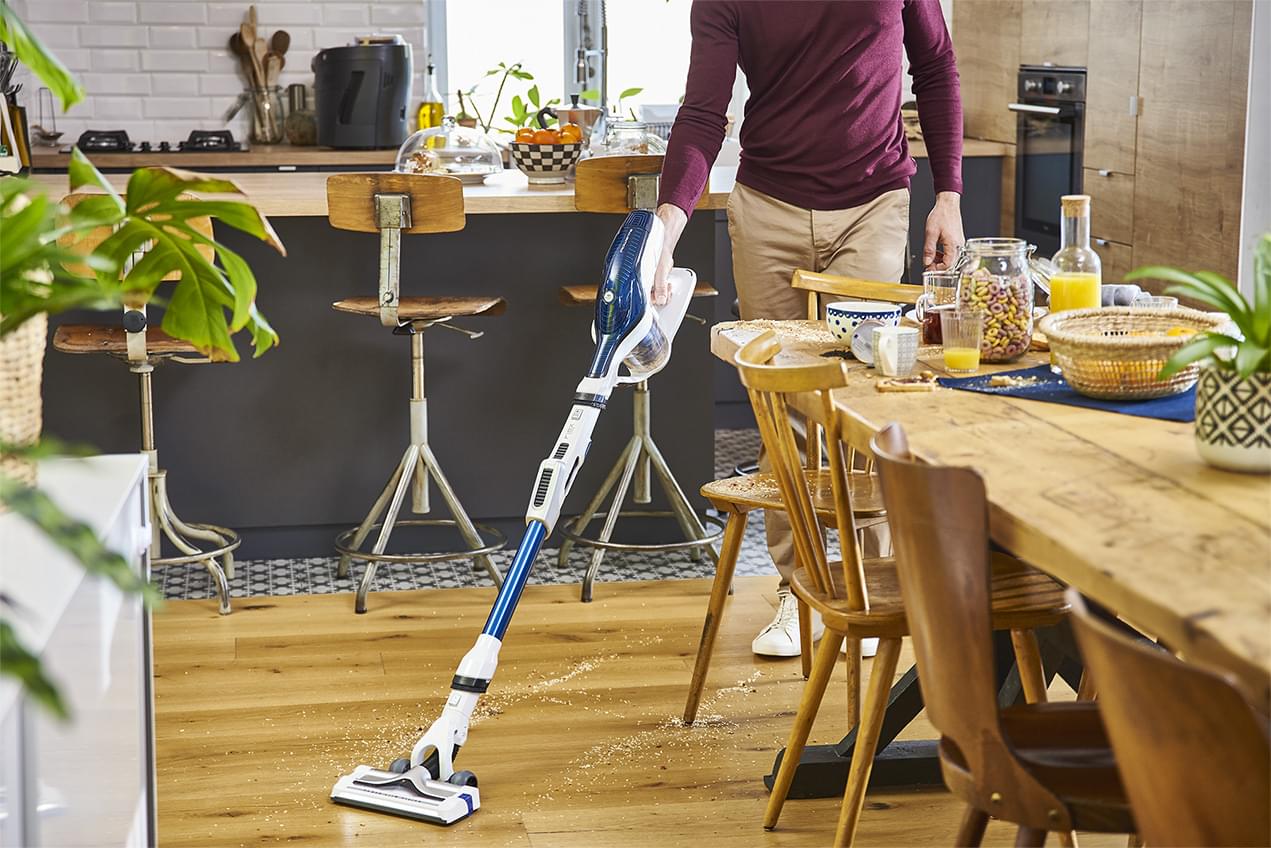 Man vacuuming in his kitchen
